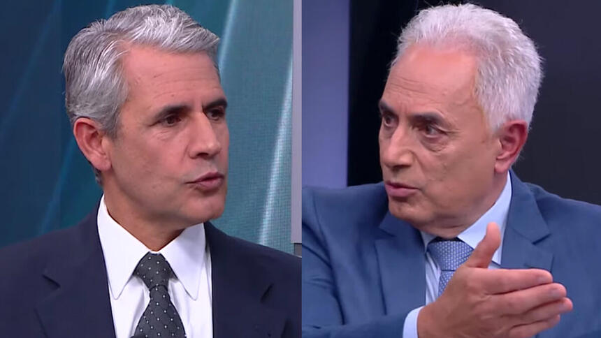 Felipe D'Avila de palitó e gravata preta, camisa social branca, sentado em frente a William Waack; William Waack de blazer cinza, gravaata azul clara e camisa social branca, gesticulando com a mão em frente a Felipe D'Avila durante entrevista na CNN Brasil