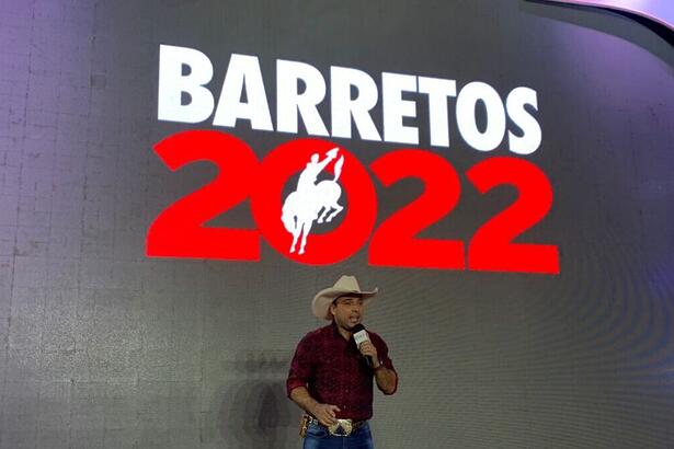 Kléber Oliveira em frente a um banner na Festão do Peão de Barretos