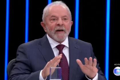 Lula em trecho da entrevista ao jornal nacional, com as mãos abertas, próximas ao rosto