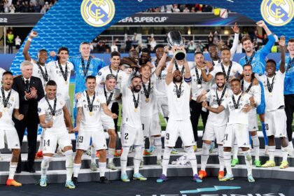 Jogadores do real madrid perfilados levantado a taça da supercopa da uefa