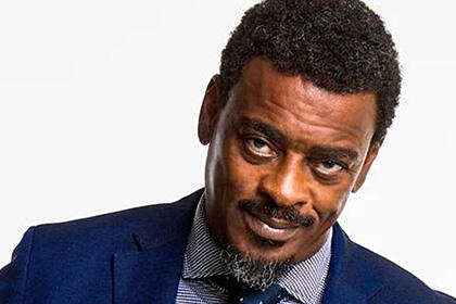 Seu Jorge de terno e gravata azuis