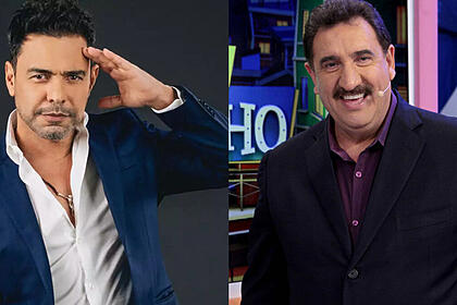 Zezé di Camargo de blazer azul, camisa social branca, com a mão na testa/ Ratinho de paltio preto e camisa roza, sorrindo, durantre gravação do seu programa no SBT
