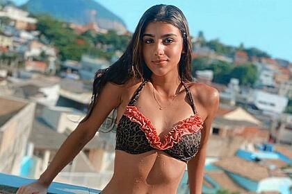 Bia Miranda de biquini marrom e vermelho, cabelo solto com os braços pra traz