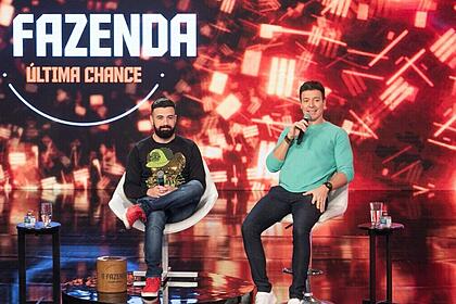 Bruno tálamo e rodrigo faro nos estúdios do hora do faro, com a logo do quadro a fazenda - última chance ao fundo