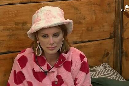Deborah na casa da árvore com uma roupa de coração e cara de triste