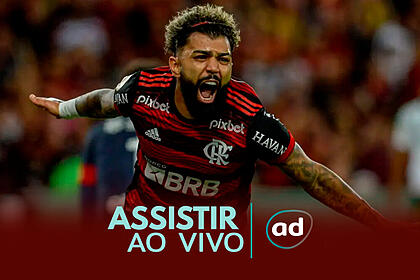 Gabigol com os braços abertos, em campo, com a camisa do Flamengo