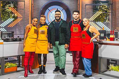 Rebecca sorrindo de calça e bota vermelha; karol conka com cabelo trançado, calça e bota preta; paulo vieira sorrindo, jaqueta e camisa preta, calça verde; jão de camisa preta, calça vermelha e sapato preto, sorrindo; duda beat de camisa regata prta, calça jeans; convidados estão usando avental vermelho com a logo do programa estampada