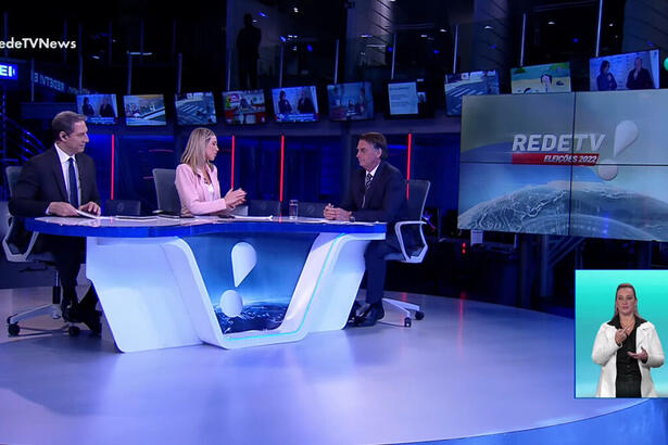 Luís Ernesto Lacombe e Érica Reis de frente a Jair Bolsonaro na bancada do RedeTV! News