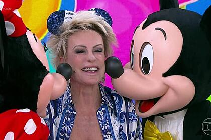Ana Maria Braga, sendo beijada por Minnie e Mickey, nos est&uacute;dios do Mais Voc&ecirc;