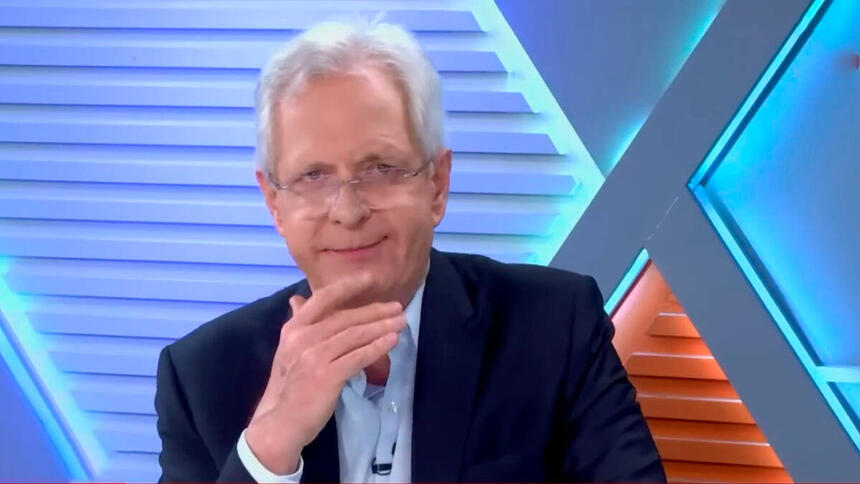 Augusto Nunes com o dedo no queixo, no estúdio da Jovem Pan News
