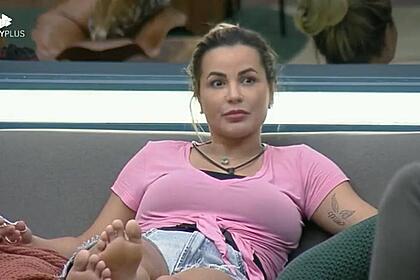 Deolane sentada no sofá da sala de A Fazenda 14