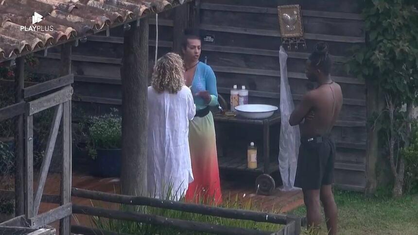 Ellen em pé de frente para Bárbara que está de costas na imagem.