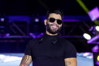 Gusttavo Lima de óculos escuros encima de um palco em um show