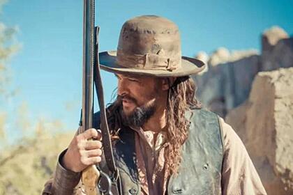 Jason Momoa com uma arma na mão