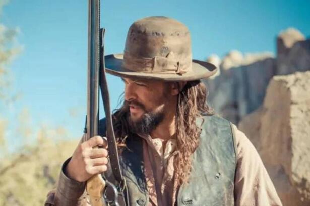 Jason Momoa com uma arma na mão