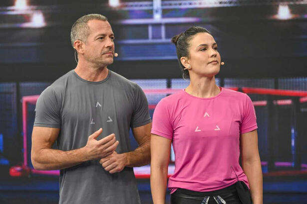 Malvino Salvador de camisa cinza, sério; Kyra Gracie de camisa rosa, semblante sério durante gravação do Faustão na Band