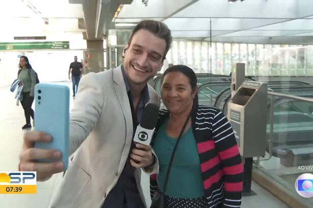 Tiago Scheuer tirando um selfie ao vivo ao lado de uma senhora
