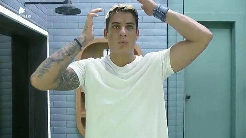 Tiago de frente para o espelho ajeitando os cabelos
