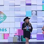 Adriane Galisteu de chapéu de Cowgirl preto, segurando fichas e microfone ao lado de Eliana durante apresentação do Teleton