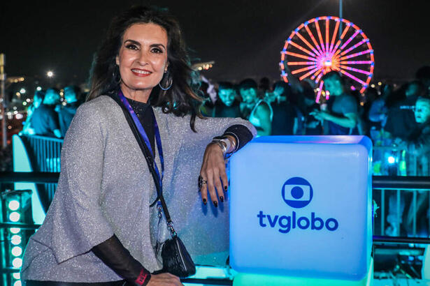 Fátima Bernardes em foto posada, do lado do totén da Globo na cobertura do Rock in Rio