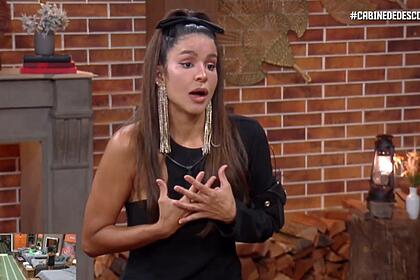 Kerline com semblante de indignação e mãos no peito enquanto concede entrevista na Cabine de Descompressão de A Fazenda 14