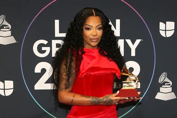 Ludmilla de vestido longo vermelho segurando seu primeiro prêmio no Grammy Latino