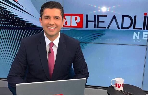 Maicon Mendes sentado em frente à mesa nos estúdios do Headiline News