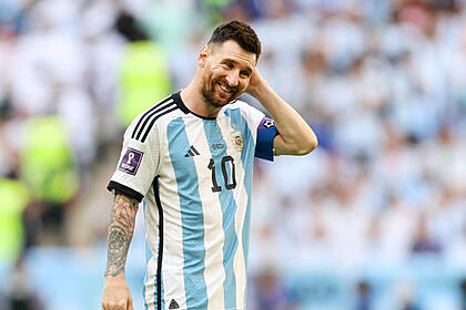 Messi com a mão na cabeça, com a camisa da argentina, em campo pela copa do mundo