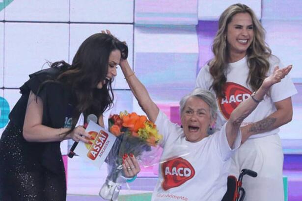 Nadja Haddad ao lado da mãe (na cadeira de rodas) e da irmã no palco do teleton 2022