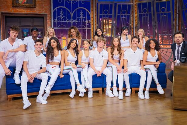 Now United de camisa e calça branca ao lado de Danilo Gentili durante gravação de entrevista para o The Noite, do SBT