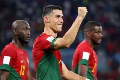 Cristiano ronaldo, olhando pela lateral, com o braço direito levantando, ao comemorar um gol com a camisa de portugal