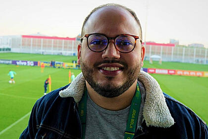 Victor pereira cobrindo um treino da seleção brasileira, ao fundo no gramado