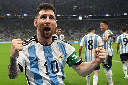 Messi com os braços abertos e punhos fechados, comemorando gol com a camisa da argentina