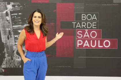 Adriana Araújo apontando para o telão no estúdio do Boa Tarde SP