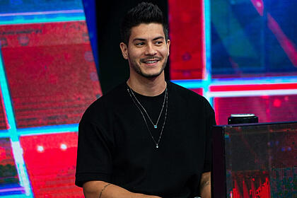 Arthur Aguiar sorrindo de camisa manga longa preta durante gravação do Faustão na Band