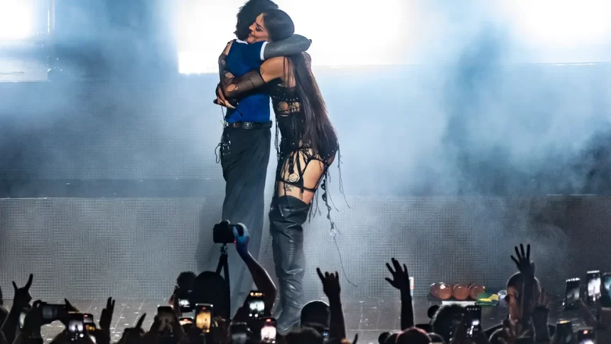 Pabllo Vittar de vestido decotado preto, abraçando o vocalista de Bring Me The Horizon durante participação em show de São Paulo