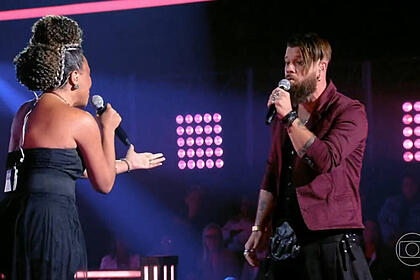 Júlio Mallaguthi e Val Andrade em trecho da batalha no palco do The Voice Brasil 11