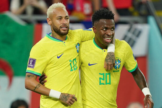 Neymar e Vinícius Jr abraçados, comemorando um gol com a camisa da Seleção na Copa