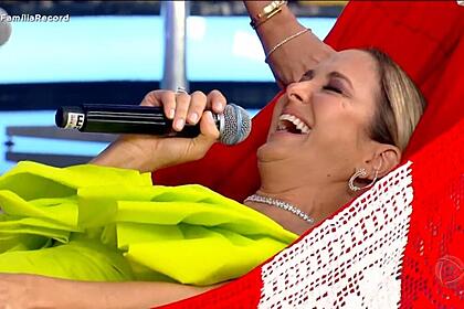 Ticiane Pinheiro sorrindo enquanto leva choques na rede que César Filho ganhou de presente no Família Record