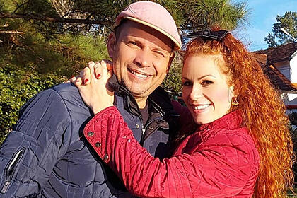 Voltaire Porto abraçado com a sua esposa Kamila Machado em um campo