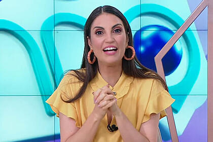 Chris flores, com uma blusa amarela, gesticulando com as mãos em trecho do fofocalizando