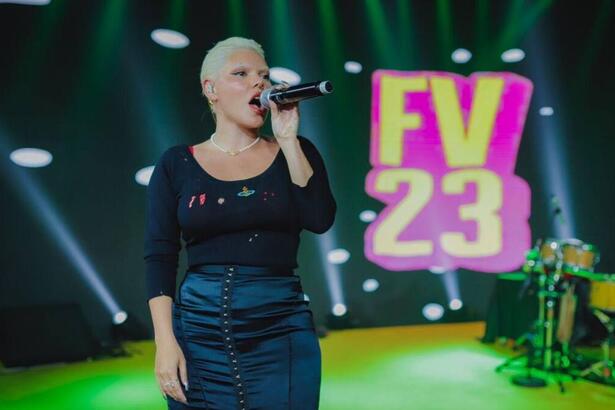 Duda Beat vestindo roupa preta segurando seu microfone cantando em ensaios do Festival de Versão de Salvador