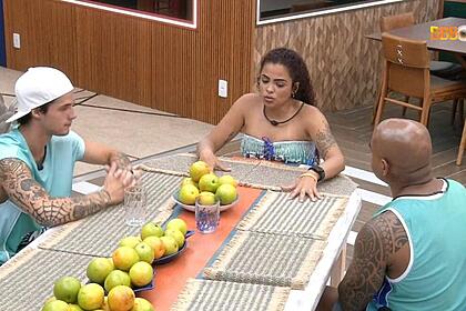 Gabriel sentado na mesa com Paula e Cezar.