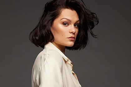 Jessie J de camisa social branca, com cabelo solto, de perfil, com semblante sério durante ensaio fotográfico