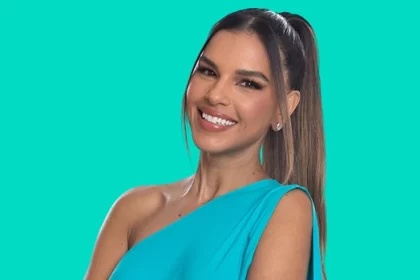 Mariana Rios sorrindo, de vestido azul, cabelo preso, num estúdio com pano verde fundo