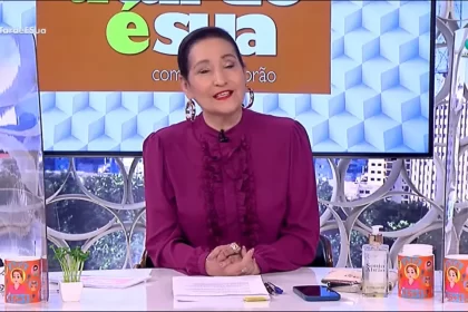 Sonia abrão com uma roupa roxa, sentada na bancada do a tarde é sua