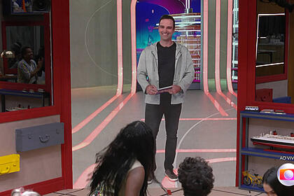 Tadeu schmidt falando com os participantes através do telão na sala do bbb 23