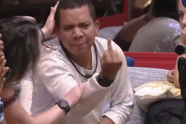 Bruno Gaa de camisa branca dando dedo pra Boninho enquanto é repreendido pelos brothers do BBB 23