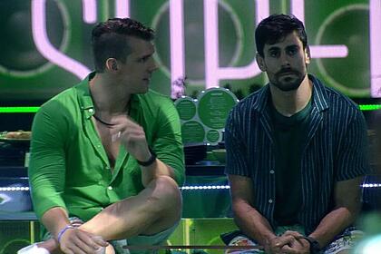 Cristian sentado ao lado de Cara de Sapato na festa do BBB 23. Cristian está vestido com uma camisa verde e Sapato com uma camisa jeans e uma preta por dentro.
