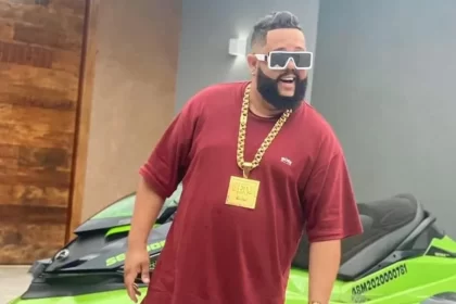 Neto LX em trecho de um clip, na frente de um carro